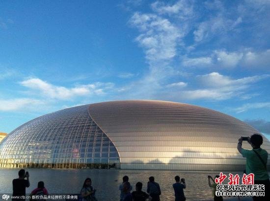 6月12日，市民及游客纷纷拍摄蓝天白云映衬下的国家大剧院。金闻 摄 图片来源：CFP视觉中国